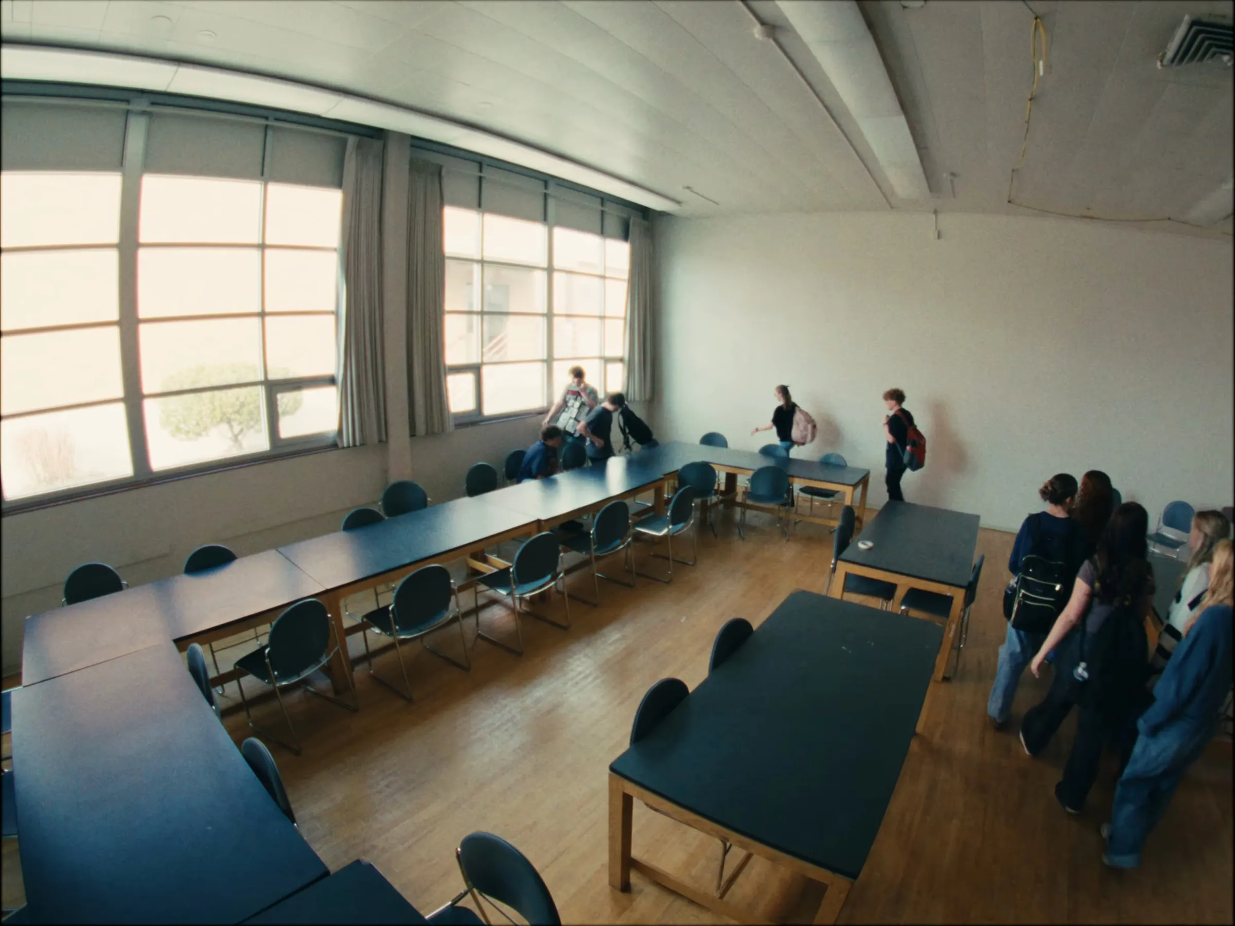 Students walking into a room of long tables