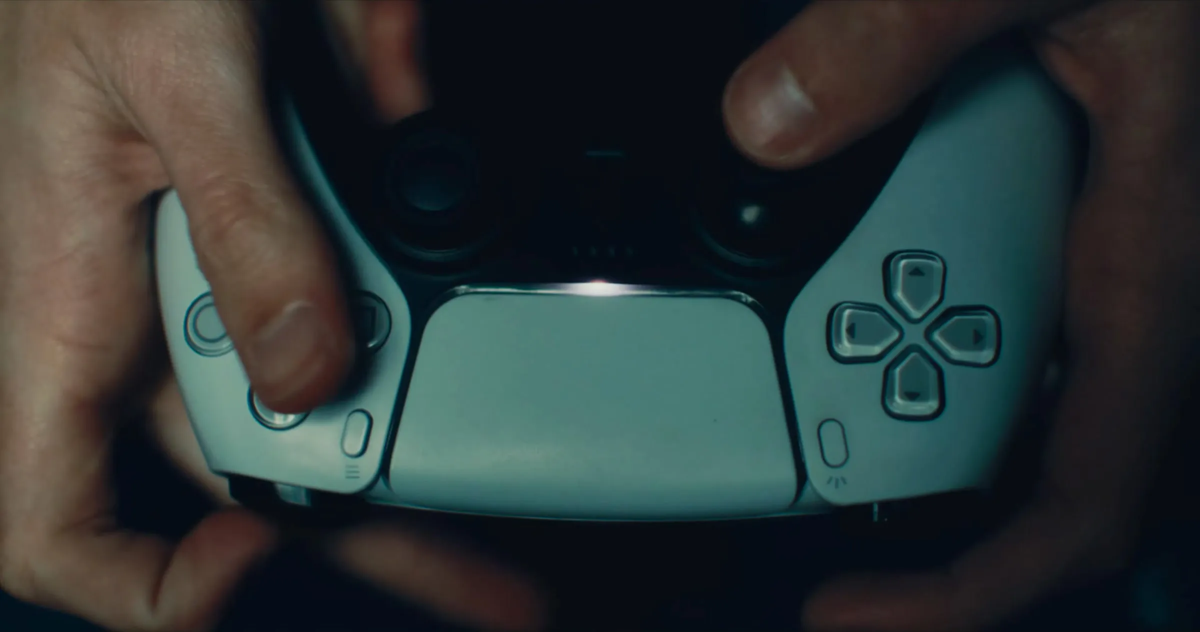 Hands gripping a PlayStation controller