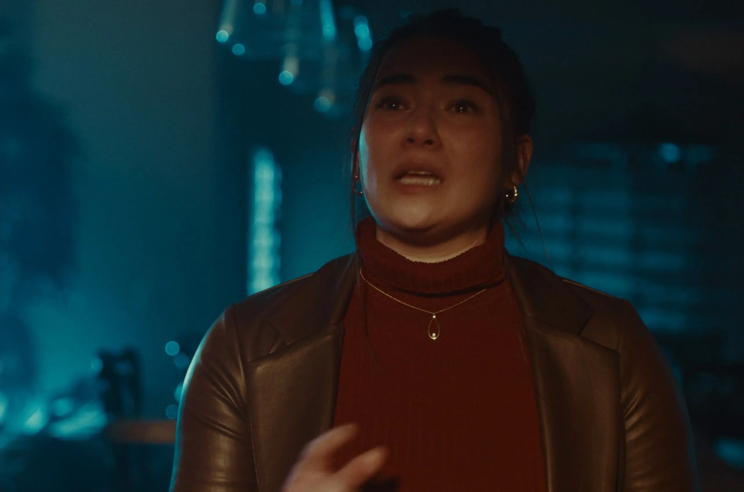 A young woman in a leather jacket, in tears