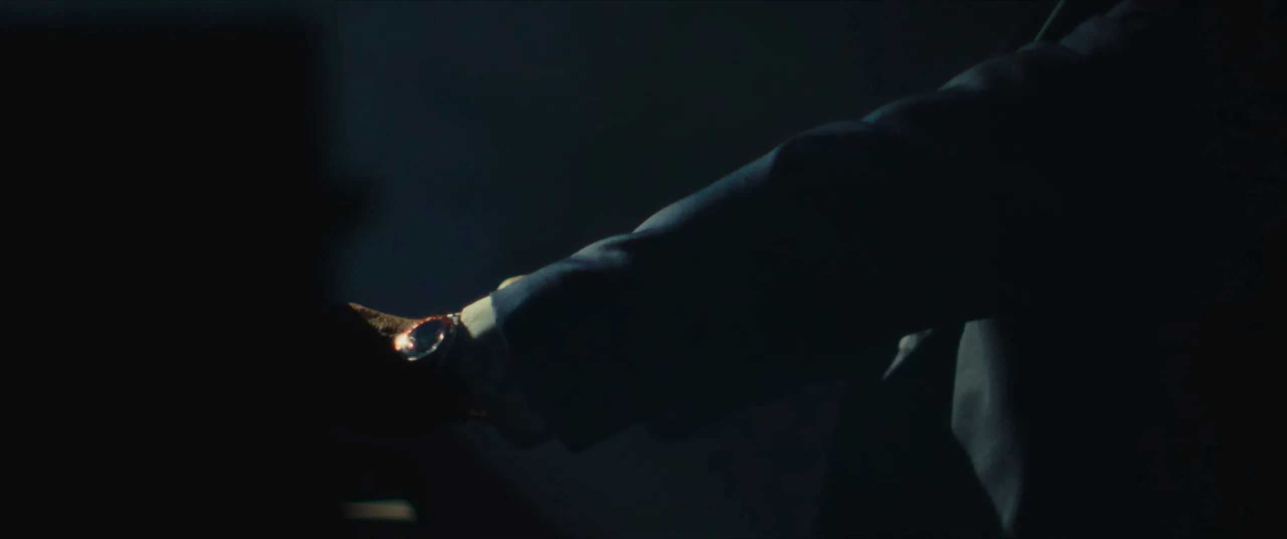 A man’s arm reaches out in the dark